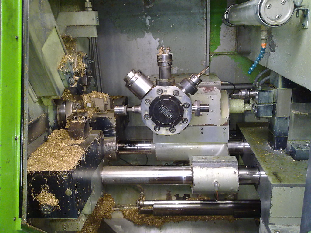 CNC-sorvi työstämässä metallikappaletta, lastut kerääntyvät koneen pohjalle.